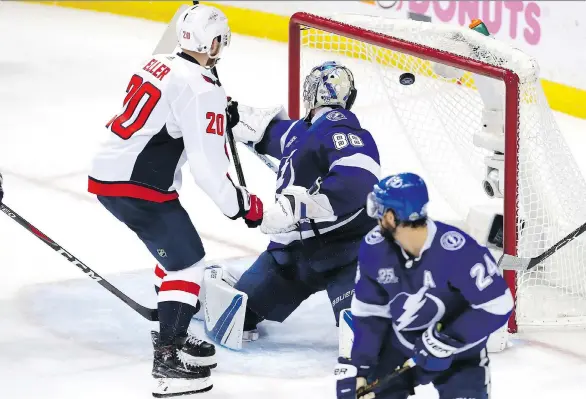  ?? MIKE CARLSON/GETTY IMAGES ?? Lars Eller scores on Lightning goalie Andrei Vasilevski­y as Washington jumps ahead 3-2 late in the second period on Sunday night. The Caps won 6-2.