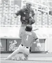  ?? ROBERTO KOLTUN/TNS ?? Marlins Cameron Maybin slides into third base as UM’s Romy Gonzalez jumps during the first inning Tuesday.