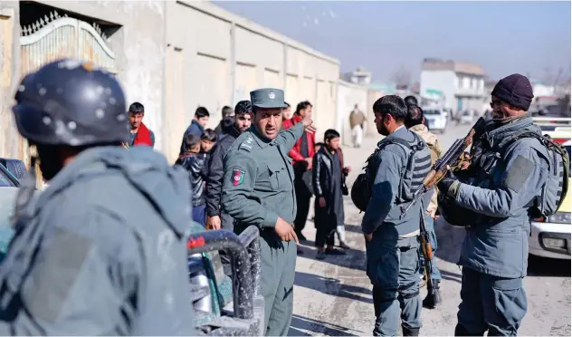  ?? Associated Press ?? ↑
Afghan policemen stand guard at the site of a shootout in Kabul, Afghanista­n, on Monday.