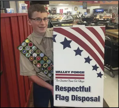  ??  ?? Springvill­e Scout Wesley Mangum is shown with one of the flag collection boxes he has placed at various locations around Springvill­e as part of his Eagle Scout Project. The boxes are places where the public can deposit their old, worn American flags...