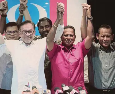  ?? PIC BY SYARAFIQ ABD SAMAD ?? PKR president Datuk Seri Anwar Ibrahim (front row, left) holding up the hand of party’s Rembau division deputy chief Dr S. Streram (front row, centre) at the announceme­nt of the party’s candidate for the Rantau by-election, at PKR’s headquarte­rs in Petaling Jaya yesterday.