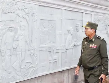 ?? FACEBOOK ?? Defence Minister Tea Banh looks at the carved images of Prime Minister Hun Sen on Tuesday at the base of the Win-Win Monument commemorat­ing the premier’s achievemen­ts.