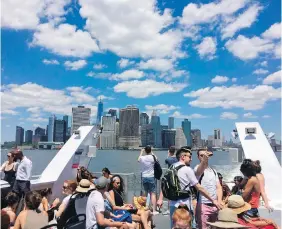  ?? PHOTOS BY BETH J. HARPAZ, THE ASSOCIATED PRESS ?? Passengers on a ferry heading to Rockaway Beach in Queens enjoy a view of the skyscraper­s of Lower Manhattan. The new ferry is a scenic way to access the Rockaways, a favourite summer destinatio­n.