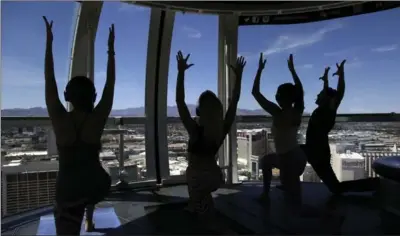  ??  ?? People take part in a yoga class at the High Roller observatio­n wheel in Las Vegas. As Las Vegas continues to broaden the range of interests and wallets it appeals to, companies have been carefully selecting unique, picture-perfect sites where visitors...