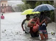  ?? DELMER MARTINEZ — THE ASSOCIATED PRESS ?? Residents wade through a flooded road carrying some belongings Nov. 4 in Progreso Yoro, Honduras.