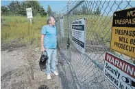  ??  ?? Former miner Ed Mack, walking with the aid of oxygen, looks at an entrance to the now-closed Denison mine where he used to work in Elliott Lake.