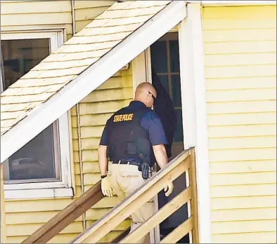  ?? Peter Hvizdak / Hearst Connecticu­t Media ?? Connecticu­t State Police enter a house on Roosevelt Drive in Derby on Sunday afternoon where a man was found dead during the search for suspected murderer Peter Manfredoni­a, 23, who was described as armed and dangerous. State Police said Manfredoni­a is believed to be armed with pistol and long guns. Manfredoni­a is also wanted in a homicide and serious assault in northeaste­rn Connecticu­t.