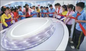  ?? CHEN XIAOGEN / FOR CHINA DAILY ?? The design of the National Speed Skating Oval captures students’ attention at a technology exhibition in Beijing in May.