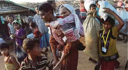  ?? REUTERS PIC ?? Rohingya Suray Khatun, 70, being carried by her son, Said-A-Lam, 38, as they enter Kutupalong refugee camp near Cox’s Bazar, Bangladesh, recently.