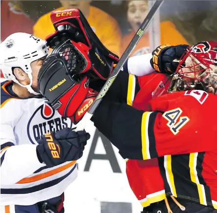  ?? LARRY MACDOUGAL/THE CANADIAN PRESS ?? Edmonton Oilers’ Milan Lucic, left, delivers a shot on Calgary Flames goaltender Mike Smith during a third-period altercatio­n in Saturday’s Battle of Alberta at the Scotiabank Saddledome, won 3-2 by the Flames. Lucic was later challenged by Tanner Glass.