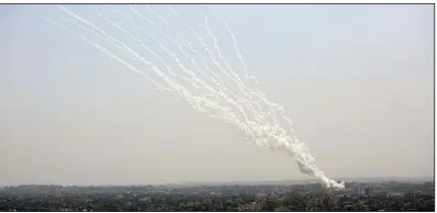  ?? (AP/Hatem Moussa) ?? A barrage of rockets rises from the Gaza Strip toward Israel on Tuesday. Israeli airstrikes in response to the attacks leveled buildings in Gaza and prompted hundreds of Hamas rockets fired in return.