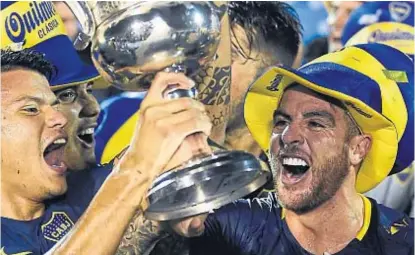  ?? (AP) ?? Alegría xeneize. Julio Buffarrini, Walter Bou, Emanuel Reynoso y todo Boca con la copa de la Superliga.