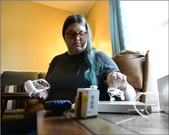  ?? ANDY CROSS — THE DENVER POST ?? Karisa Hunt prepares her insulin pump for an insulin replacemen­t at her home in Commerce City on Friday.