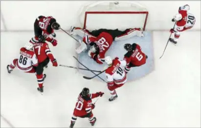  ?? JULIO CORTEZ — THE ASSOCIATED PRESS ?? Devils goaltender MacKenzie Blackwood, top center, lies on the puck after making a save against the Carolina Hurricanes during the first period on Saturday in Newark. The Devils won, 2-0.