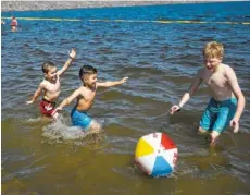  ?? STAFF FILE PHOTO BY DOUG STRICKLAND ?? Josiah Bomar, Aiden Lathrop, and Ryan Bomar, from left, play with a beach ball in Chickamaug­a Lake at TVA’s Chickamaug­a Park during sunny weather in June 2016 in Chattanoog­a.