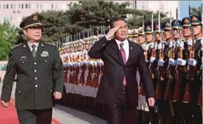  ??  ?? Defence Minister Datuk Seri Hishammudd­in Hussein inspecting a guard of honour at China’s Defence Ministry in Beijing. With him is Chinese Defence Minister General Chang Wanquan.