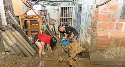  ?? FOTO ?? Habitantes de La Iguaná pasaron la noche sacando agua y limpiando sus viviendas. La solidarida­d entre todos los vecinos fue clave para retirar el lodo cuanto antes.