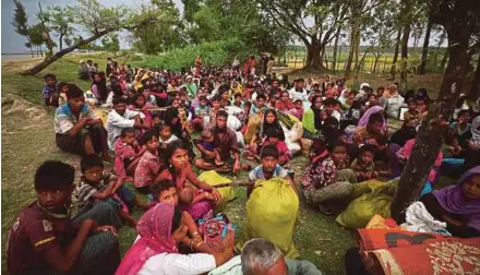  ?? REUTERS PIC ?? Rohingya refugees waiting to receive permission from the Bangladesh­i army to continue their way after crossing the Bangladesh-Myanmar border, at a port in Teknaf, Bangladesh, on Tuesday.