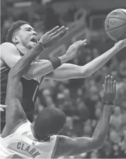  ?? FRANKLIN/AP ROSS D. ?? Suns guard Devin Booker, top, is fouled as he goes up for a shot by Rockets forward Gary Clark, bottom, during the second half Saturday in Phoenix.