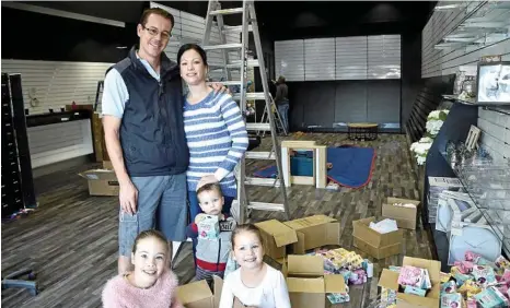  ??  ?? OPENING TOMORROW: news extra Central City owners Trent and Lindal Donovan with their children (from left) Ella, 8, Tayla, 5, and Peter, 2, unpack the new-look Margaret St store. PHOTO: BEV LACEY