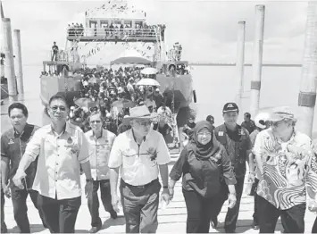  ??  ?? NEW FERRY SERVICE: (From left) Julaihi, Manyin, Rohani and others disembark from the ferry at Triso Jetty after the launching ceremony.