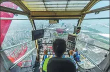  ??  ?? The BRICS New Developmen­t Bank Headquarte­rs Building ( 150 meters high, 30 floors) in Shanghai Pudong Free Trade Zone. The tower crane driver controls the boom over the Expo Park site.