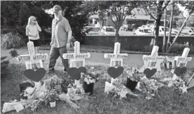  ?? JOSE LUIS MAGANA/AP ?? Capital Gazette reporter E.B. Furgurson III looks at crosses representi­ng his five colleagues at a makeshift memorial in Annapolis, Md.