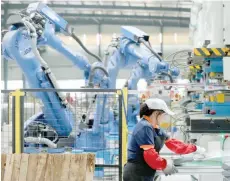  ?? — Reuters ?? A woman works at a workshop of a company manufactur­ing air-conditione­rs in Huaibei, Anhui province, China.