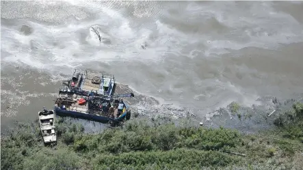  ?? JASON FRANSON/ THE CANADIAN PRESS ?? Crews work to clean up an oil spill on the North Saskatchew­an River near Maidstone on Friday. Husky Energy has said between 200,000 and 250,000 litres of crude oil and other material leaked into the river on Thursday from its pipeline.