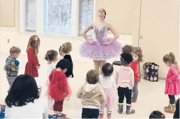  ?? MICHAEL WALSH/COURANT COMMUNITY ?? A ballerina from the University of Hartford’s Hartt School Community Division shows various stretches to children in West Hartford.“We have a good relationsh­ip with the surroundin­g community,” says Marcus Thomas, the chair of the Hartt School’s department of music and performing arts management.