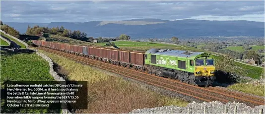  ?? STEVE SIENKIEWIC­Z ?? Late afternoon sunlight catches DB Cargo’s ‘Climate Hero’-liveried No. 66004, as it heads south along the Settle & Carlisle Line at Greengate with 40 four-wheel MEA wagons forming the 6E97/15.56 Newbiggin to Milford West gypsum empties on October 12.