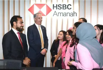  ??  ?? Milne (second left) and Chief Executive Officer of HSBC Amanah Malaysia Berhad, Oz Ahmed (left) having a light moment with their staff after official launch of HSBC Amanah Malaysia Sri Petaling Branch. — Bernama photo