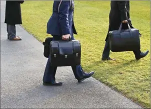  ?? MARK WILSON/GETTY IMAGES/AFP ?? A military aide carries the nuclear football as he walks towards Marine One with US President Donald Trump, on December 2, in Washington, DC.