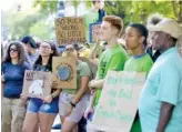  ?? STAFF PHOTO BY ERIN O. SMITH ?? Young people hold up signs during a Climate Strike on Friday in front of the Tennessee Aquarium. A candlelit climate vigil also is planned for Friday near the Hunter Museum.