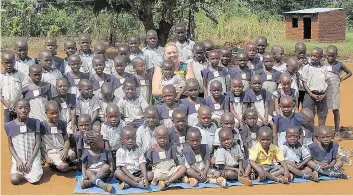  ?? Photo courtesy of Geri Sutts ?? Geri Sutts is pictured with some of the children she has supported through her organizati­on, Save African Child Uganda. Sutts, a local retired teacher, is planning to return to the village of Buwundo in May.