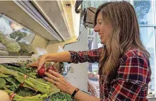  ?? [PHOTO BY ERIECH TAPIA, THE OKLAHOMAN] ?? Chelsey Simpson, co-owner of Urban Agrarian, stacks produce on the shelves at the new downtown Edmond location.