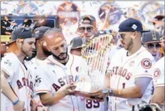  ?? AFP ?? The Houston Astros’ Marwin Gonzalez and Carlos Correa (right) hold the World Series trophy during their victory parade on Friday.