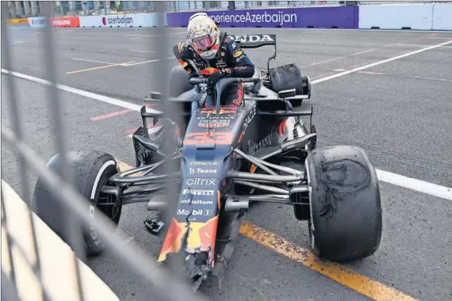 ??  ?? Max Verstappen se baja de su Red Bull después de chocarse con las proteccion­es del circuito de Bakú a causa de un reventón en el neumático trasero izquierdo.