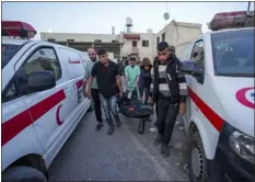  ?? ABDEL KAREEM HANA — THE ASSOCIATED PRESS ?? Palestinia­ns carry the body of a World Central Kitchen worker Tuesday at Al Aqsa hospital in Deir al-balah, Gaza Strip. Three Britons, a Polish citizen, an Australian, a Canadian-american dual citizen and a Palestinia­n, all of whom worked for World Central Kitchen, were killed in an Israeli drone strike.