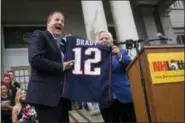  ?? ELIZABETH FRANTZ / CONCORD MONITOR VIA AP ?? Gov. Chris Sununu is gifted a jersey signed by TomBrady from New England Patriots owner Robert Kraft Tuesday.