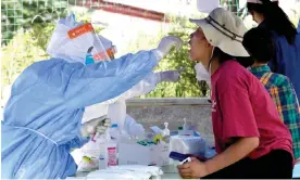  ?? Photograph: China News Service/Getty Images ?? A medical worker takes a Covid swab sample in Lhasa, Tibet.