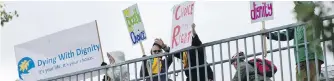  ??  ?? Participan­ts in a Dying with Dignity Canada rally wave to traffic from the Galloping Goose Regional Trail overpass at Douglas Street in October 2014.