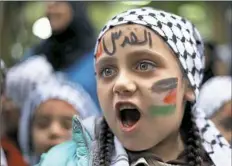  ?? Bilal Hussein/Associated Press ?? A girl with her face painted with the colors of the Palestinia­n flag and Arabic words reading “Jerusalem is for us” chants slogans during a sit-in in the Bourj al-Barajneh Palestinia­n refugee camp Wednesday in Beirut, Lebanon.