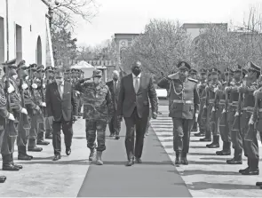  ?? PRESIDENTI­AL PALACE VIA AP ?? U.S. Defense Secretary Lloyd Austin, center, walks with acting Afghan Minister of Defense Yasin Zia as they review an honor guard at the presidenti­al palace in Kabul, Afghanista­n, on Sunday.