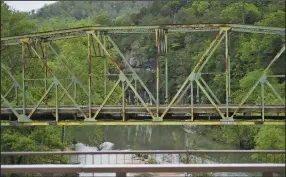  ?? (NWA Democrat-Gazette/Charlie Kaijo) ?? The old Pruitt bridge was still standing but no longer open to traffic Thursday as demolition work began. The bridge on Arkansas 7 over the Buffalo River was designed and built in 1931 by Fred Luttjohann of Topeka, Kan., who constructe­d several bridges in Arkansas.