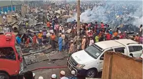  ?? AFP PIC ?? Onlookers gathering at a Rohingya refugee camp which was destroyed in a fire, in Ukhia, Cox’s Bazar in Bangladesh yesterday.