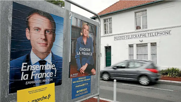  ??  ?? Posters of presidenti­al election candidates Emmanuel Macron and Marine Le Pen are displayed in Saint-Josse, northern France. Macron’s campaign has been rocked by a computer hack that dumped its campaign emails online just before the country entered a...