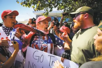  ?? Gabrielle Lurie / The Chronicle ?? Demonstrat­ors John Turano (center) and Antonio Foreman (right) argue as people mill around after the brief UC Berkeley appearance by Yiannopoul­os, an ultraconse­rvative provocateu­r.