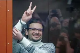  ?? YURY KOCHETKOV/POOL VIA AP, POOL ?? Ilya Yashin, a Russian opposition activist and former municipal deputy of the Krasnosels­ky district, gestures and smiles in 2022 as he stands in a defendant’s cubicle in a courtroom prior to a hearing in Moscow.