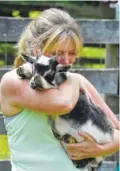  ?? KEN KOONS/BALTIMORE SUN/TRIBUNE NEWS SERVICE ?? Serrina Davis hugs a pygmy goat during goat yoga.